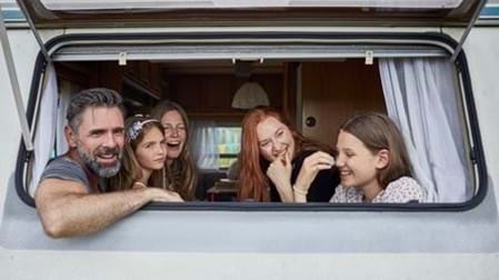 Family looking out of caravan window